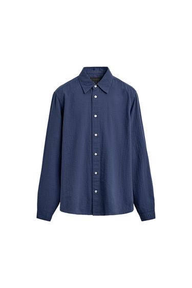 Navy blue long-sleeve shirt with a textured finish, a classic collar, and white buttons on a white background.