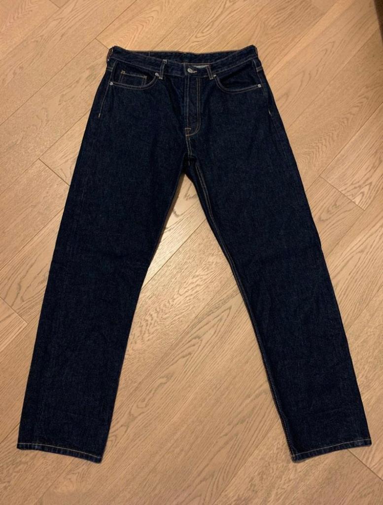 Front view of dark jeans with front pockets and visible seams.