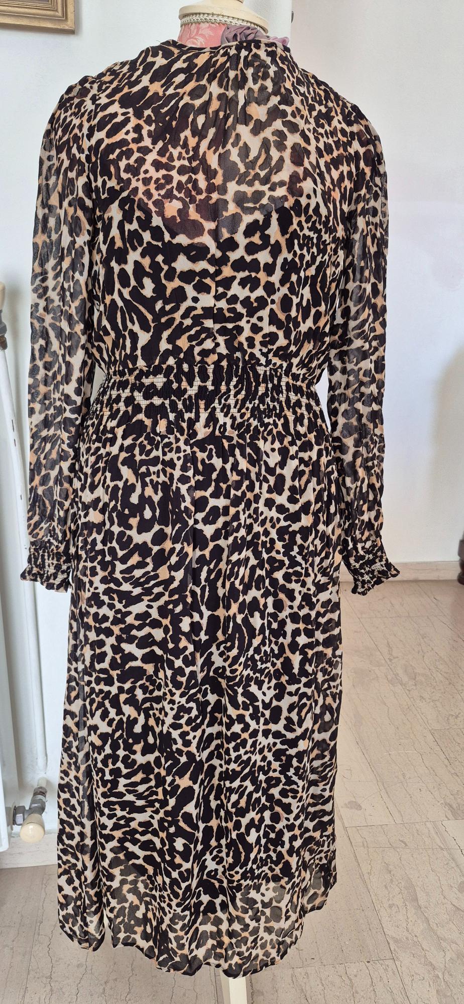 Long leopard print dress in brown and black tones, displayed on a mannequin in a well-lit indoor setting.