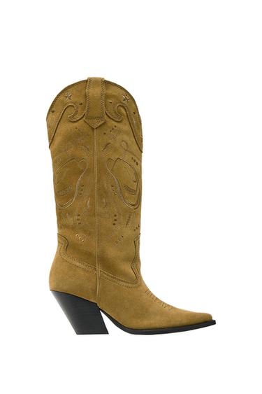 Light brown high-heeled cowboy boot with embroidered details and a hat and star design on the side.