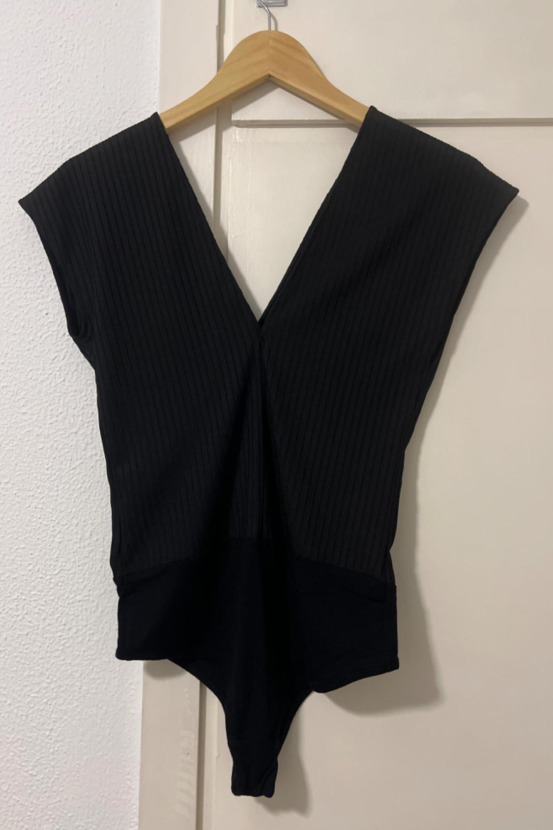 Front view of black bodysuit with V-neck and ribbed fabric.