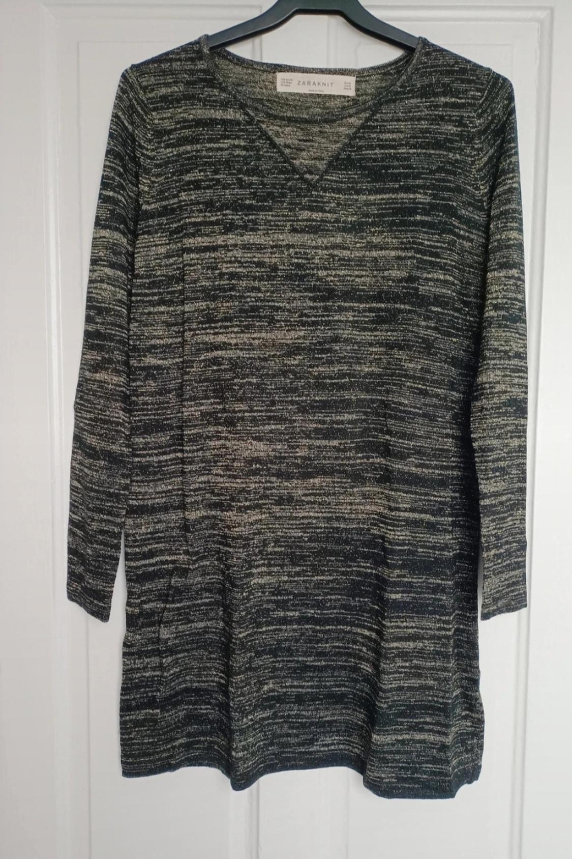 Front view of mottled grey jumper with V-neck and long sleeves.