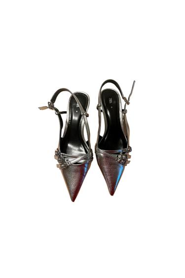 Silver high heels with a pointed toe and adjustable straps. Visible text: "ZARA". White background.
