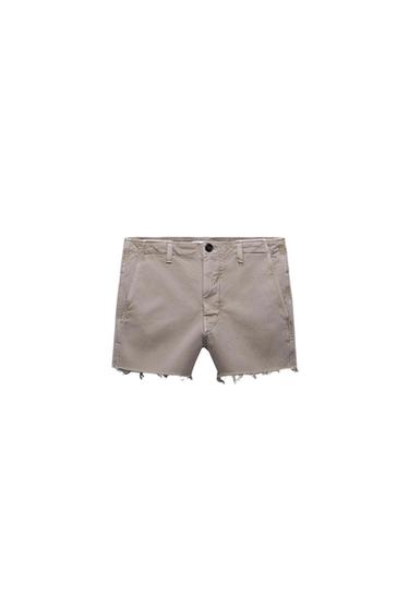 Front view of beige shorts with a frayed hem and side pockets.