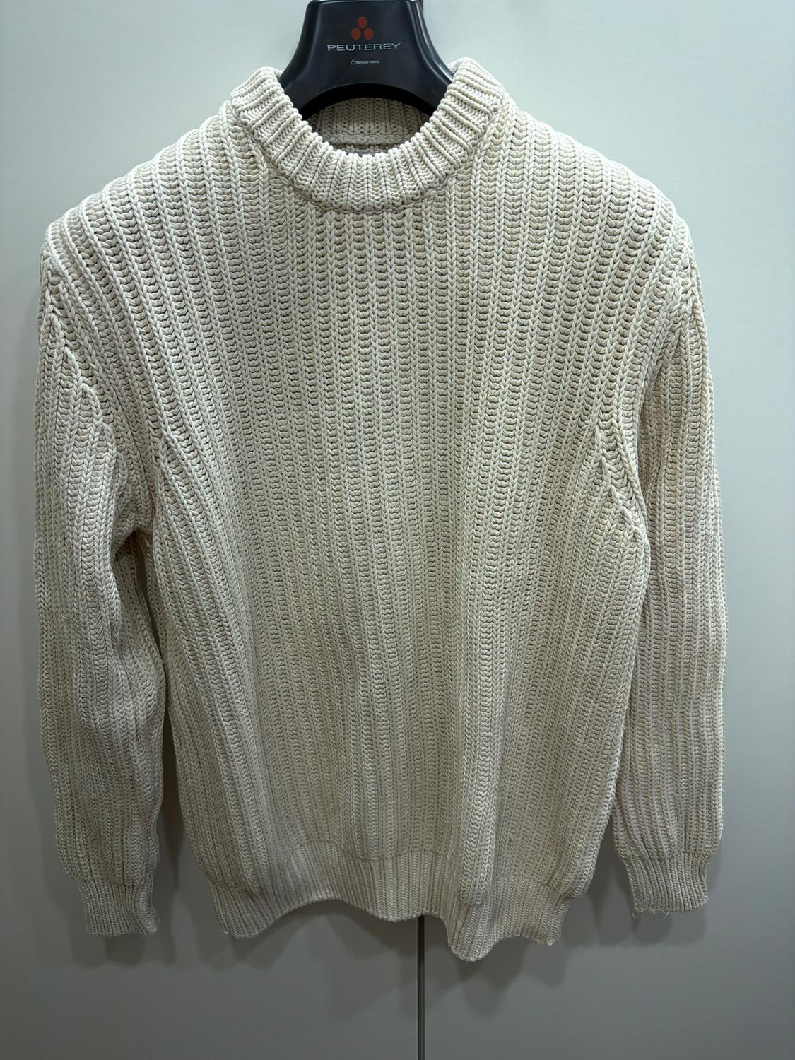 Chunky cream-coloured knitted jumper hanging on a black hanger with the "PEUTEREY" brand visible on the hook.