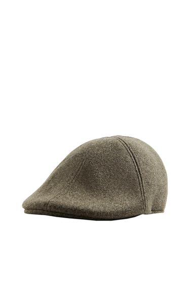 Brown wool flat cap on a white background, with visible stitching and a classic design.