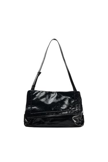 Shiny black handbag with flap and adjustable strap, on a white background. Elegant and modern design.
