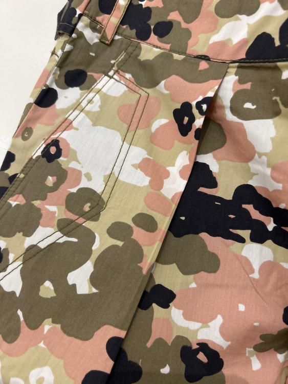 Camouflage print trousers in green, pink, and black tones, with pockets and visible seams.