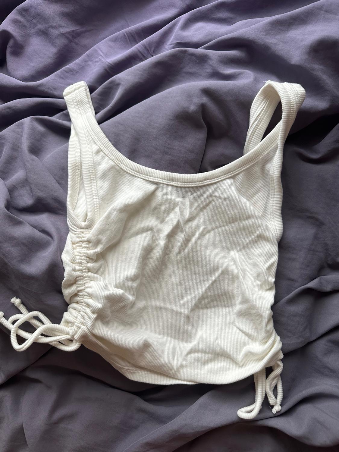 White shirred camisole top over lilac crinkled fabric.
