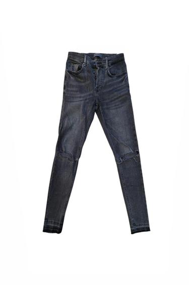 Front view of dark jeans with front pockets and distressed knee details.