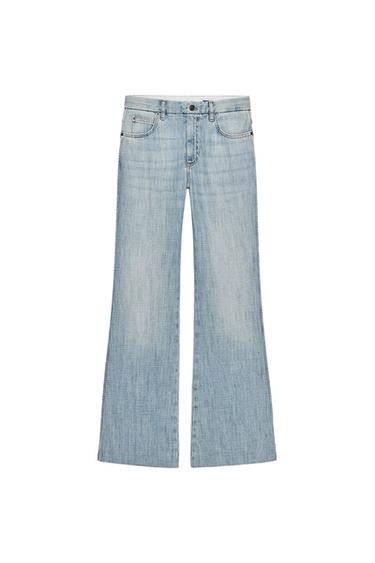 Front view of light blue jeans, low rise, five pockets, flared leg, front zip and button fastening.