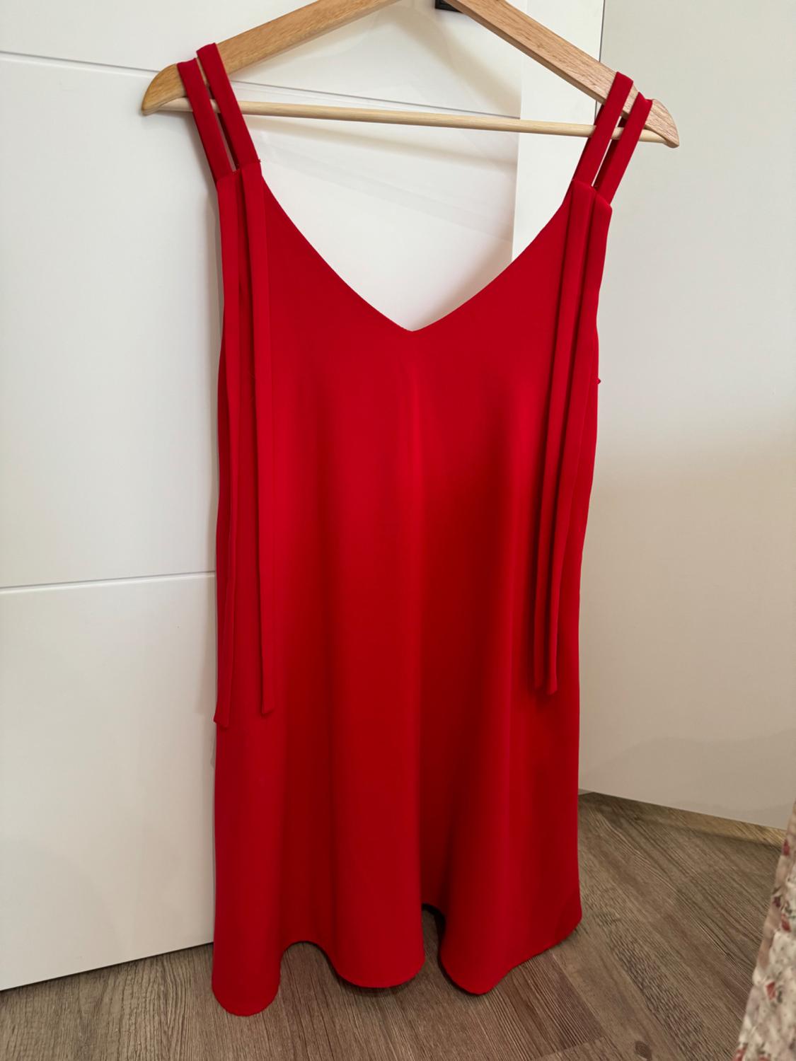 Front view of a sleeveless red dress with double straps and a V-neck.