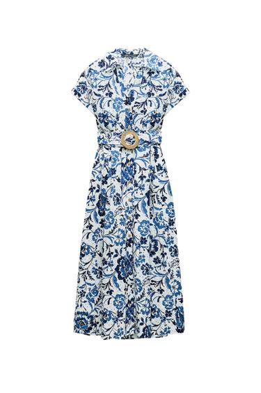 White dress with blue floral print, short sleeves, and a gold buckle belt. Elegant and summery design.