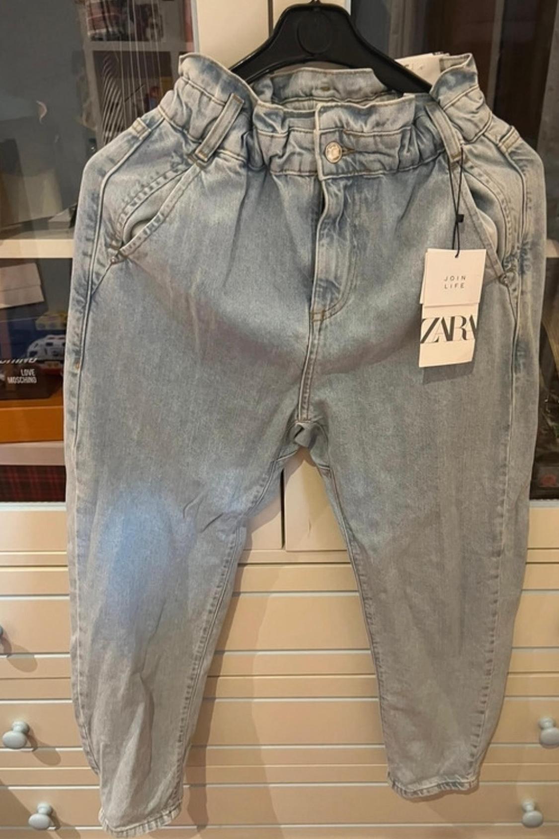 Front view of light blue jeans with side pockets and ruched elasticated waistband.