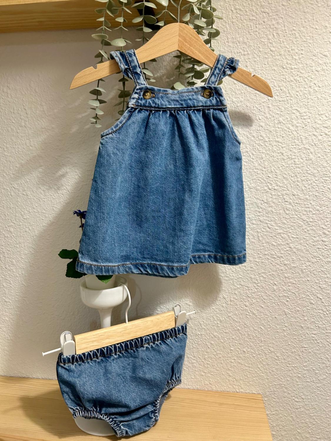 Front view of a blue girls' dress and pants set with straps and decorative buttons.