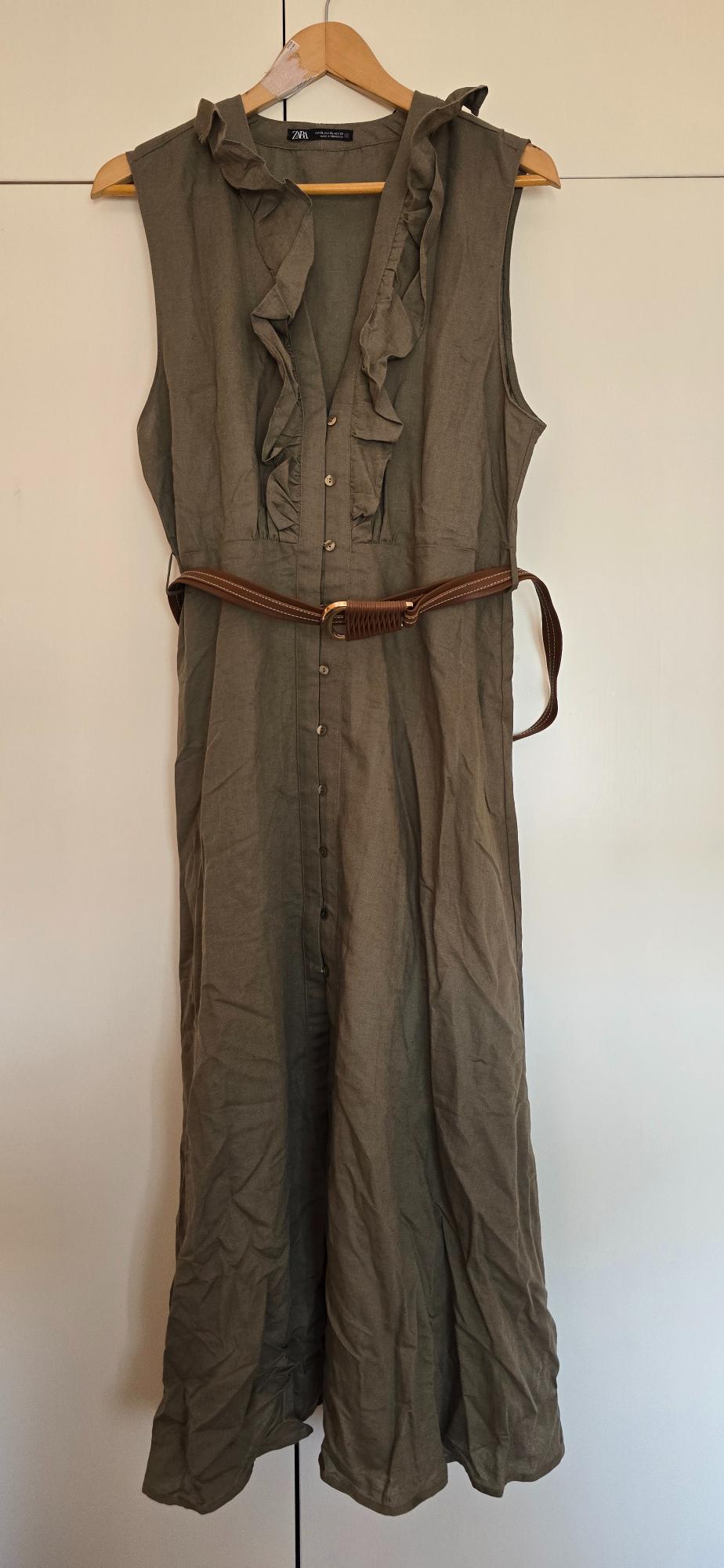 Olive green ZARA dress on a wooden hanger. Sleeveless design, V-neck with ruffles, front buttons and brown belt.