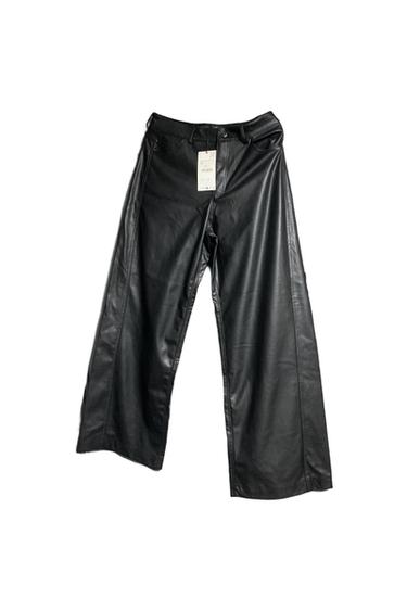 Black faux leather trousers with a swing tag on the front, against a white background.