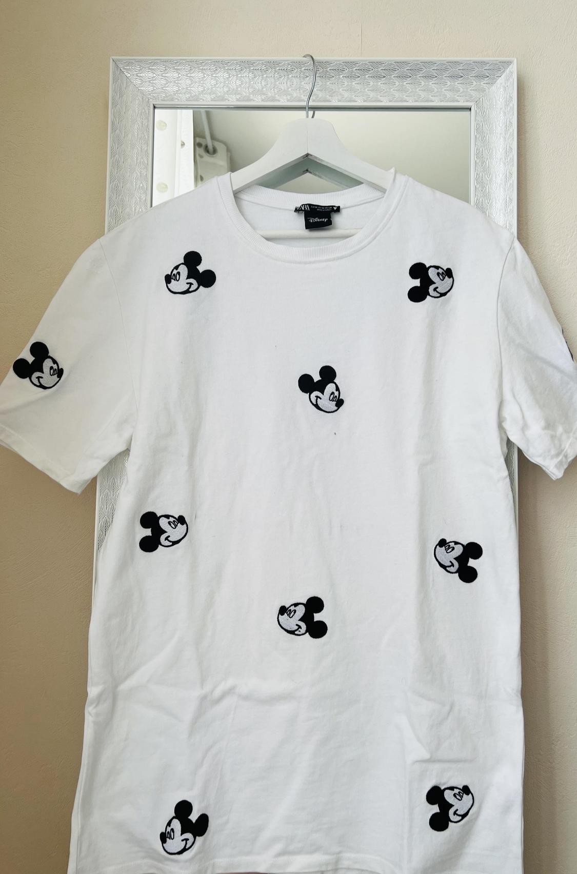 Front view of a white t-shirt with a repeated black Mickey Mouse print.