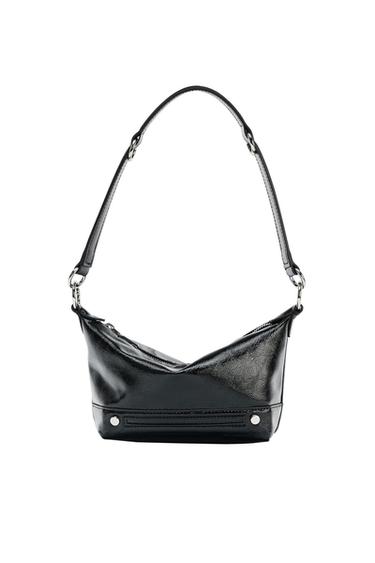 Black faux leather handbag with adjustable strap and silver metallic details, on a white background.