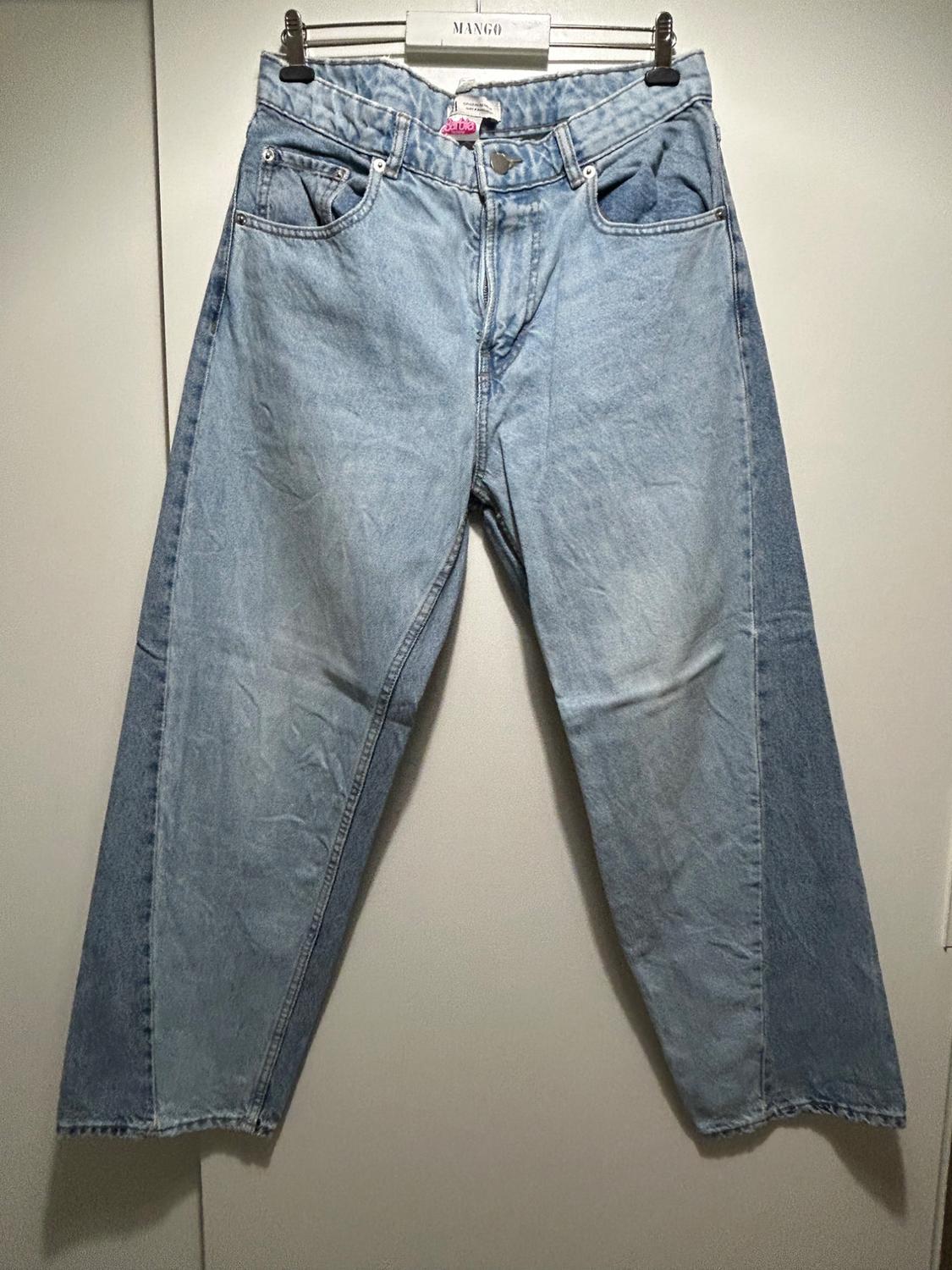 Light blue denim jeans hanging on a hanger with the "MANGO" brand visible. Plain white background.