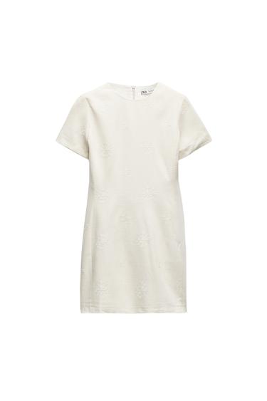 Front view of a white dress with short sleeves and star embroidery