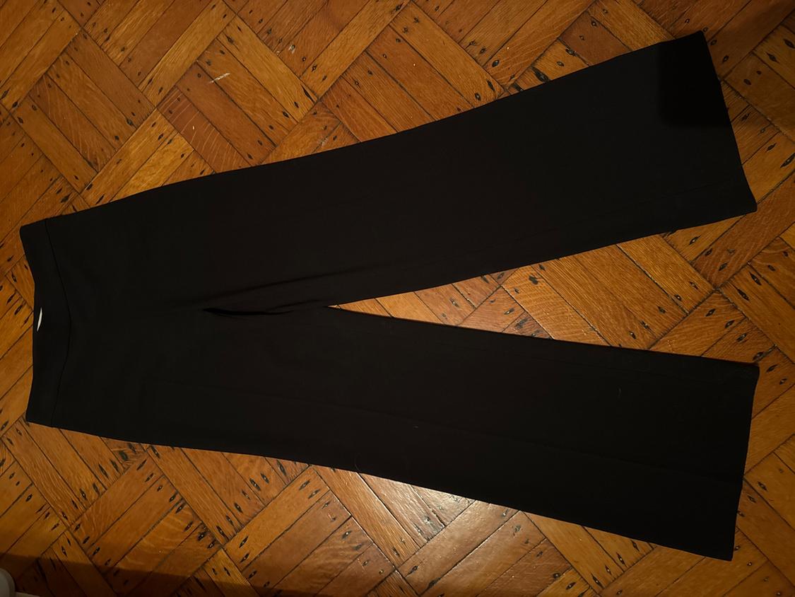 Black wide-leg pants on a herringbone wood floor.