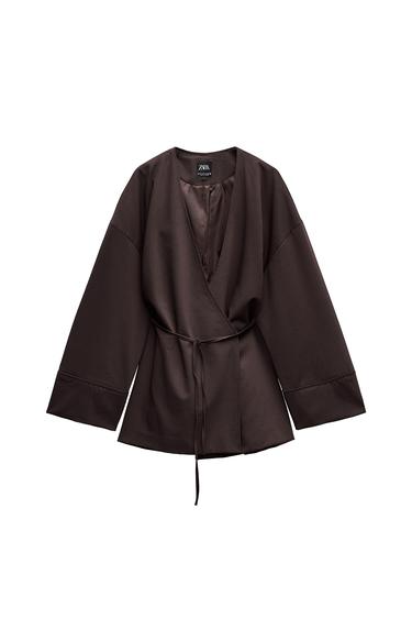 Front view of a brown jacket with belt and long flared sleeves.