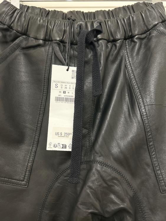 Black leather trousers with elasticated waist and drawstring. Visible tag with price of US $259 and size S.