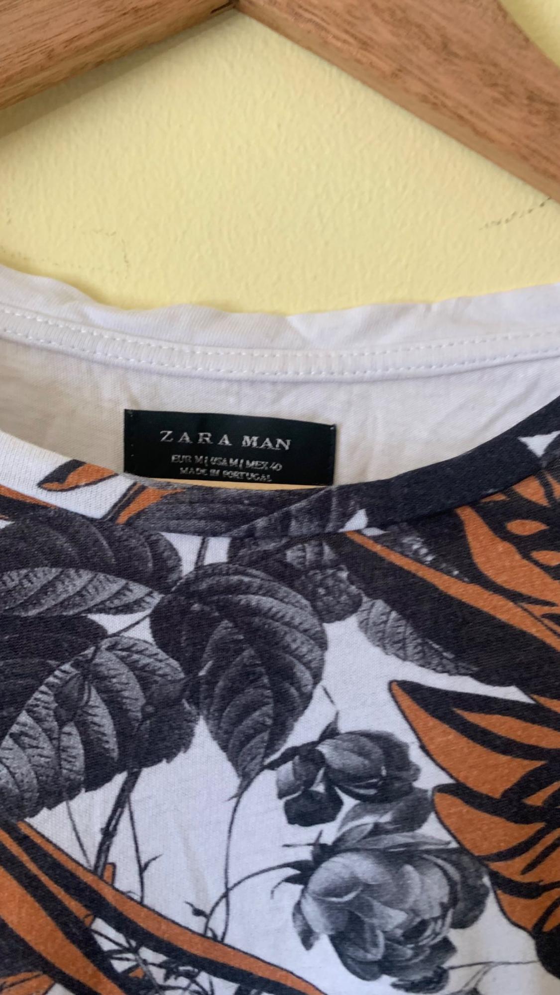 T-shirt collar detail with floral print and 'ZARA MAN' label.