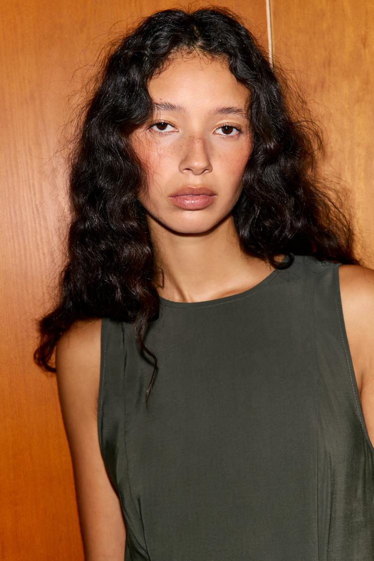 "Close-up of a sleeveless, round-neck petrol dress."