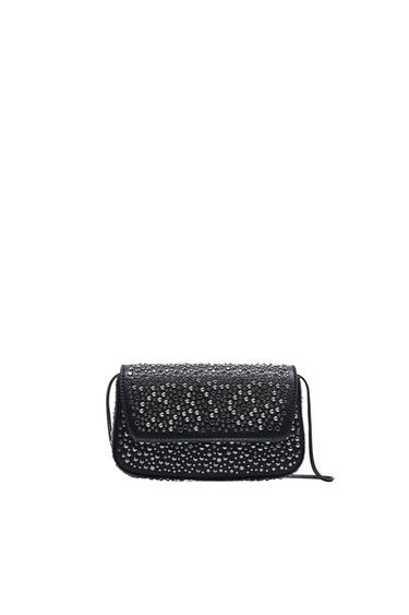 Black handbag with a flap decorated with silver rhinestones on a white background. Elegant and modern design.