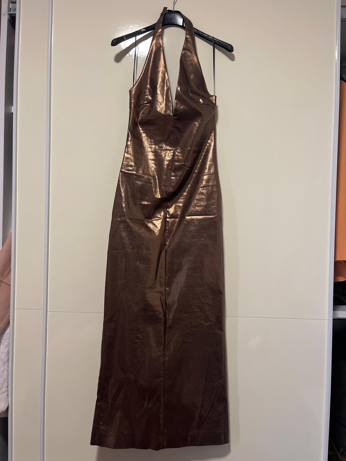 Shiny brown maxi dress with a halter neck, hanging on a black hanger against a light background.