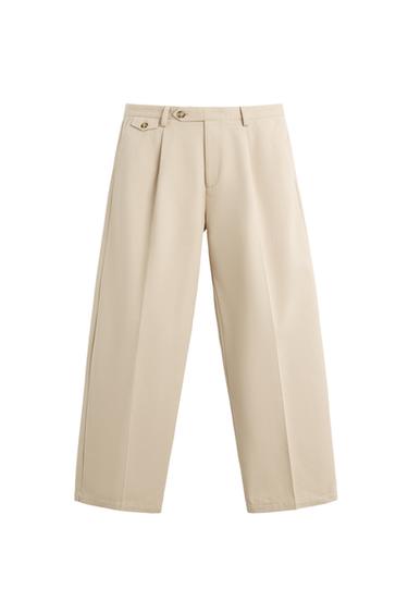 Front view of beige pleated trousers with button-down front pockets