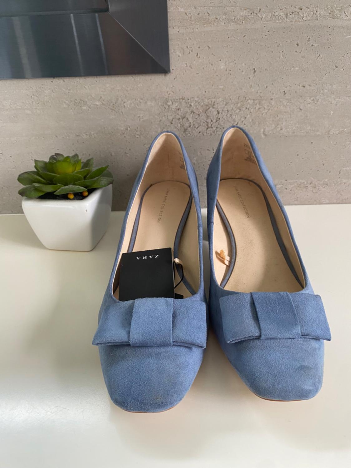 Front view of blue shoes with decorative bow