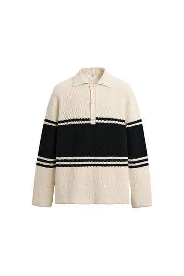 Front view of a beige jumper with black and white stripes, polo neck and button fastening.