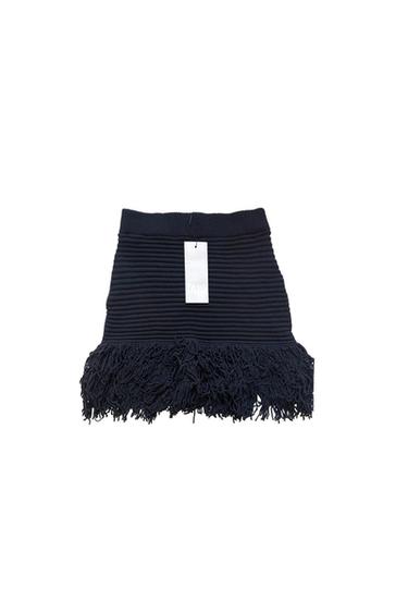 Navy blue ribbed knit mini skirt with a fringed hem. Central white label with the text ZARA. White background.