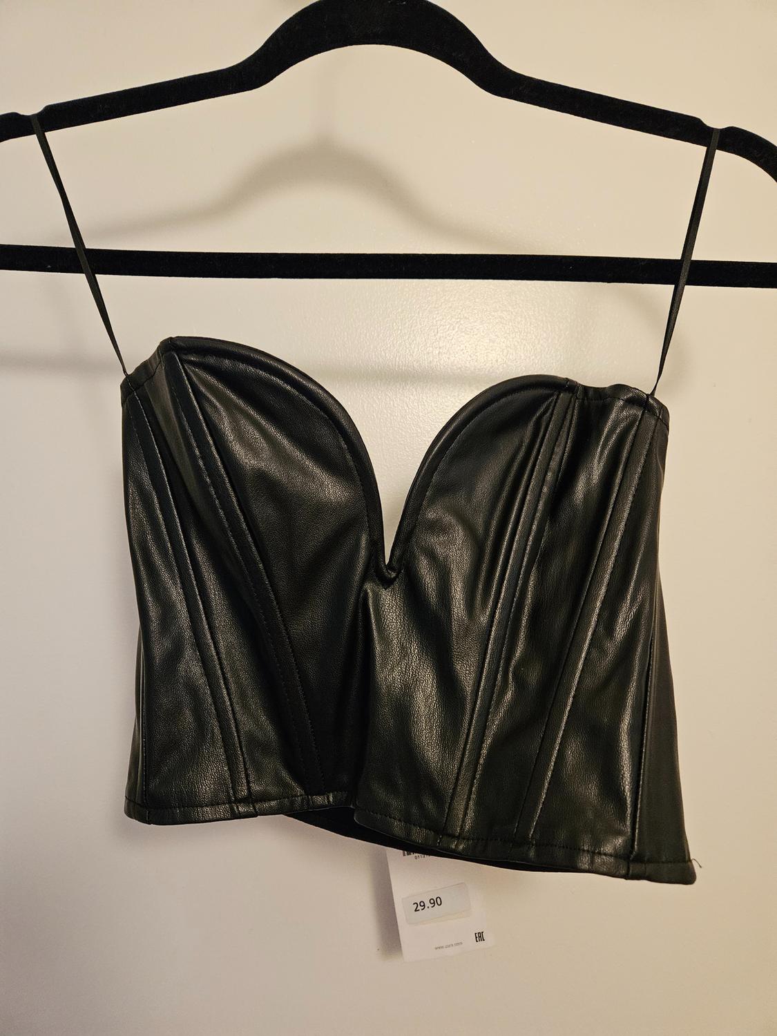 Front view of a black top with thin straps and a sweetheart neckline, price visible on tag.