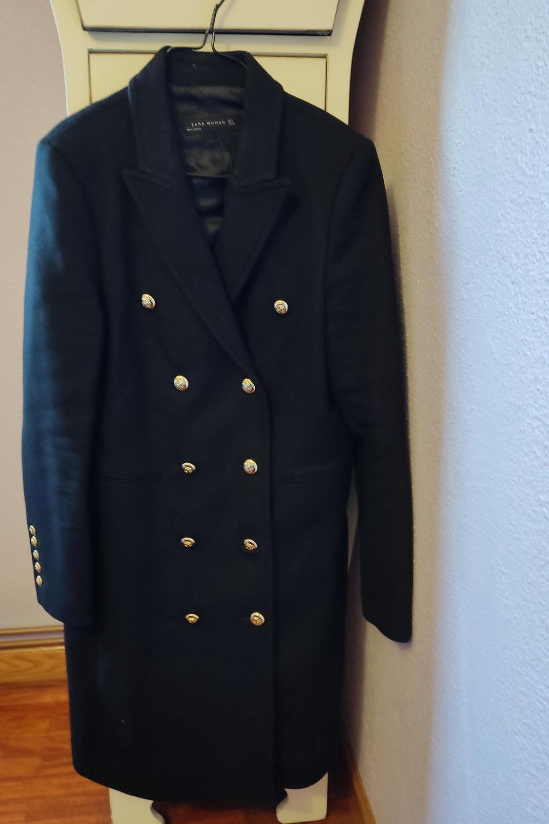 Front view of black coat with gold double-breasting and side pockets.