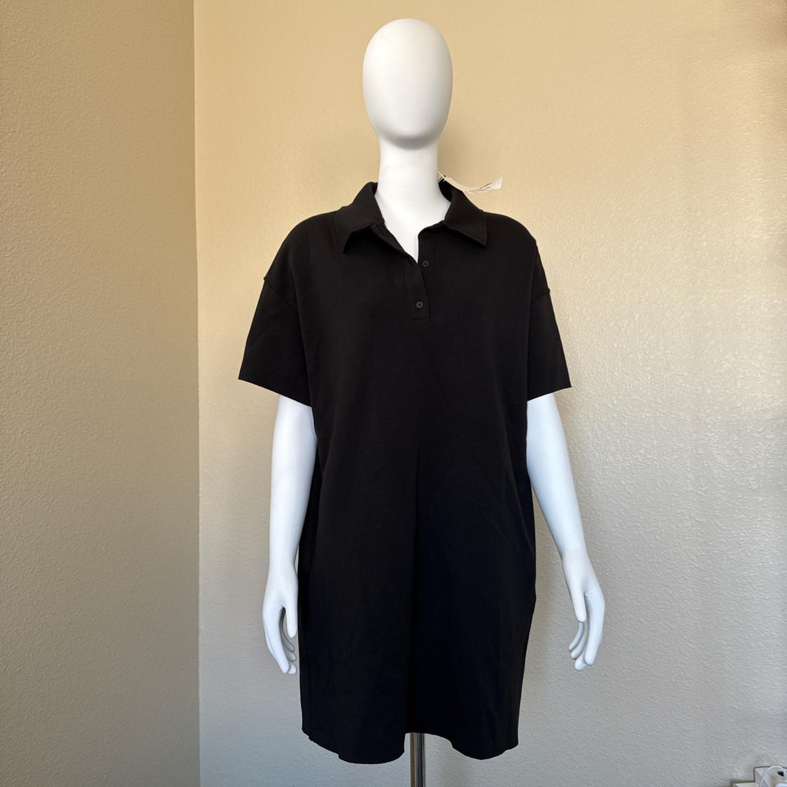 Mannequin in a black short-sleeved polo neck dress in a minimalist setting with a beige wall.
