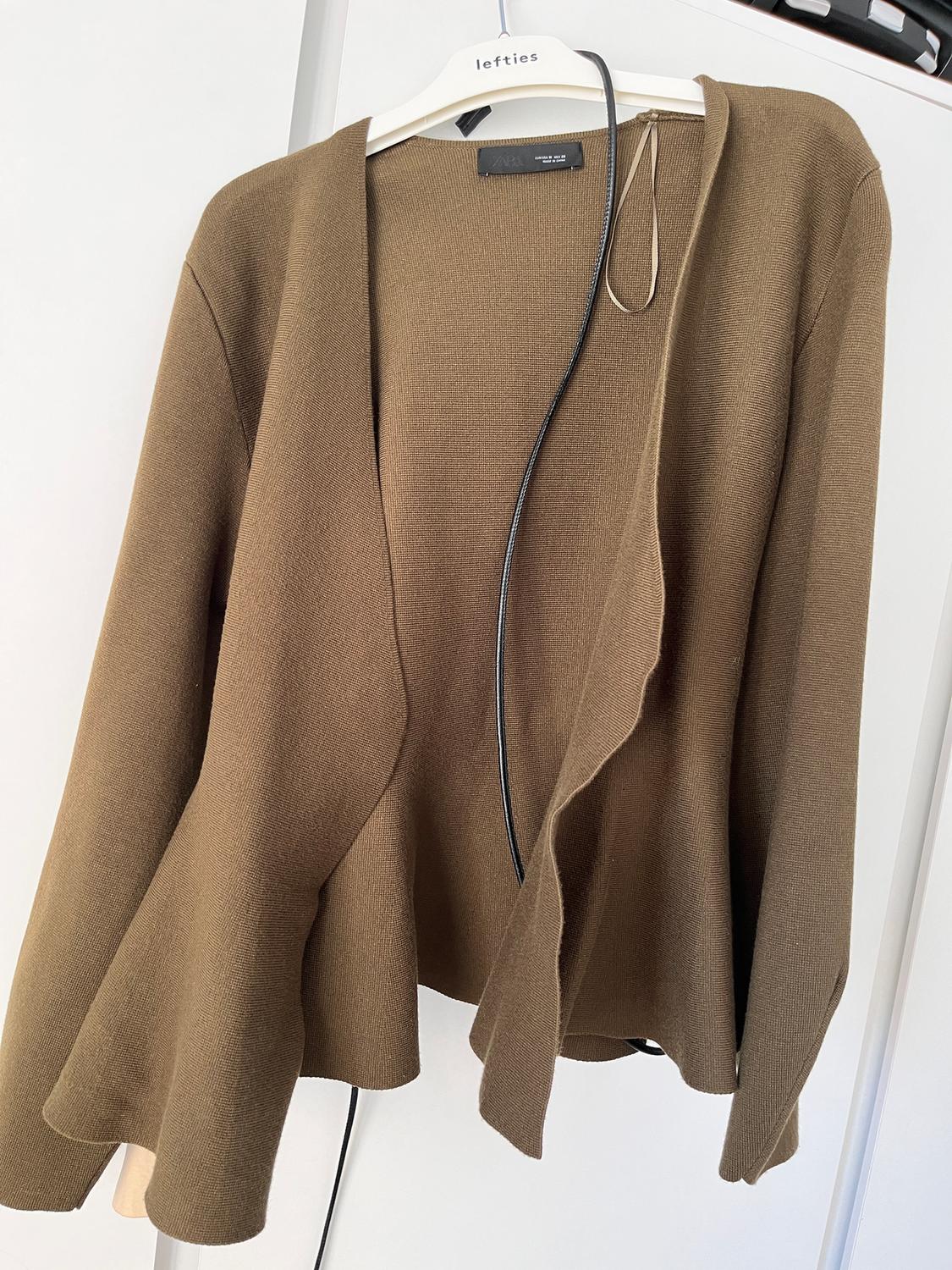 Brown cardigan hanging on a white hanger with the "lefties" brand. White background and visible black tag details.