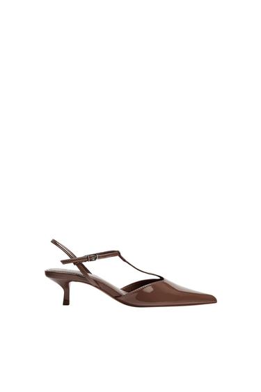 Brown low-heeled shoe with a glossy finish, pointed toe, and buckled straps. Side view on a white background.