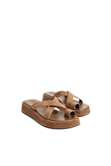 Brown platform sandals with crossover straps and toe detail, on a white background.