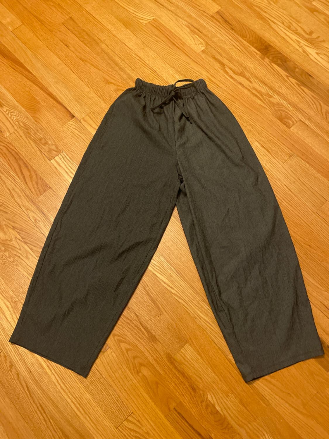 Front view of dark long trousers with elasticated waist and drawstring.
