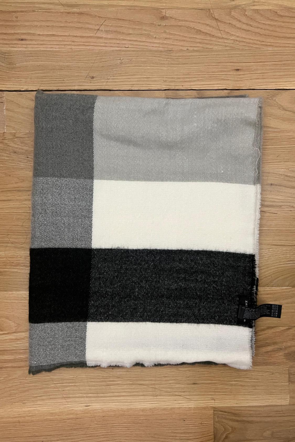Front view of checked scarf in white, grey, and black.