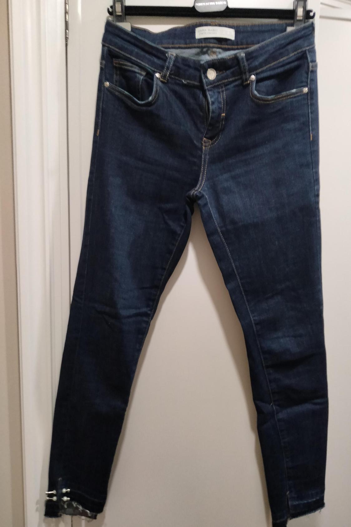 Front view of blue jeans with front and back pockets, button and zip fastening.