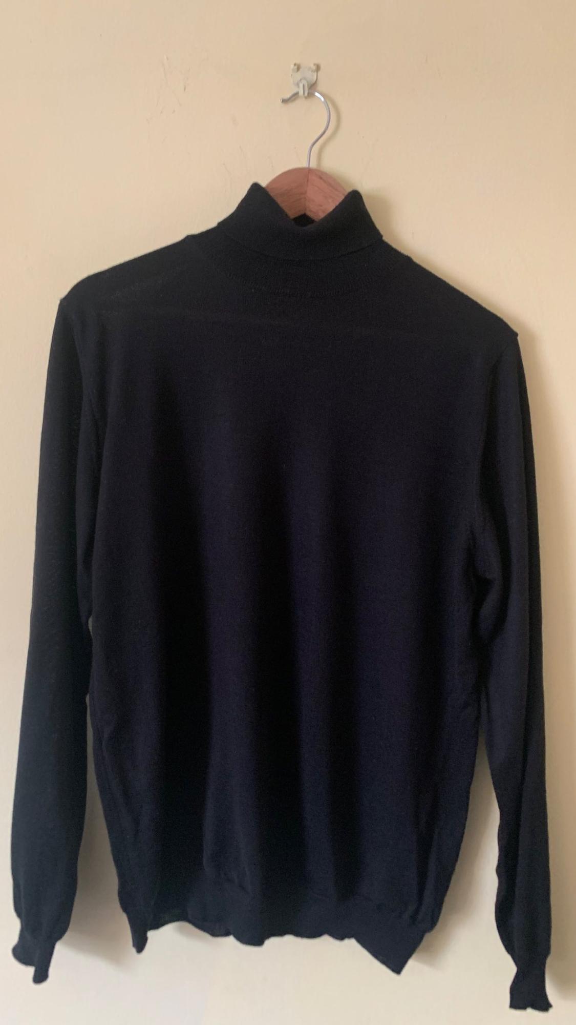 Rear view of a black roll-neck jumper with long sleeves.
