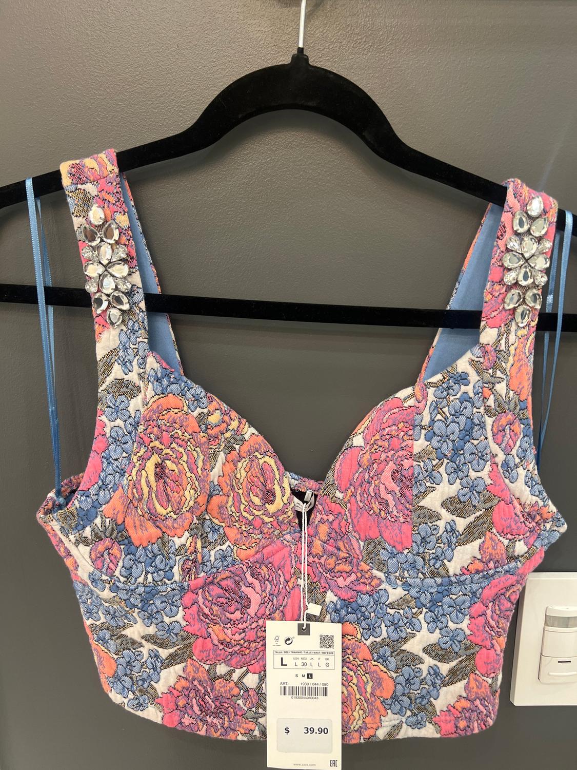 Multicolor floral top with rhinestones on the straps, hanging on a black hanger. Price tag of $39.90 visible.