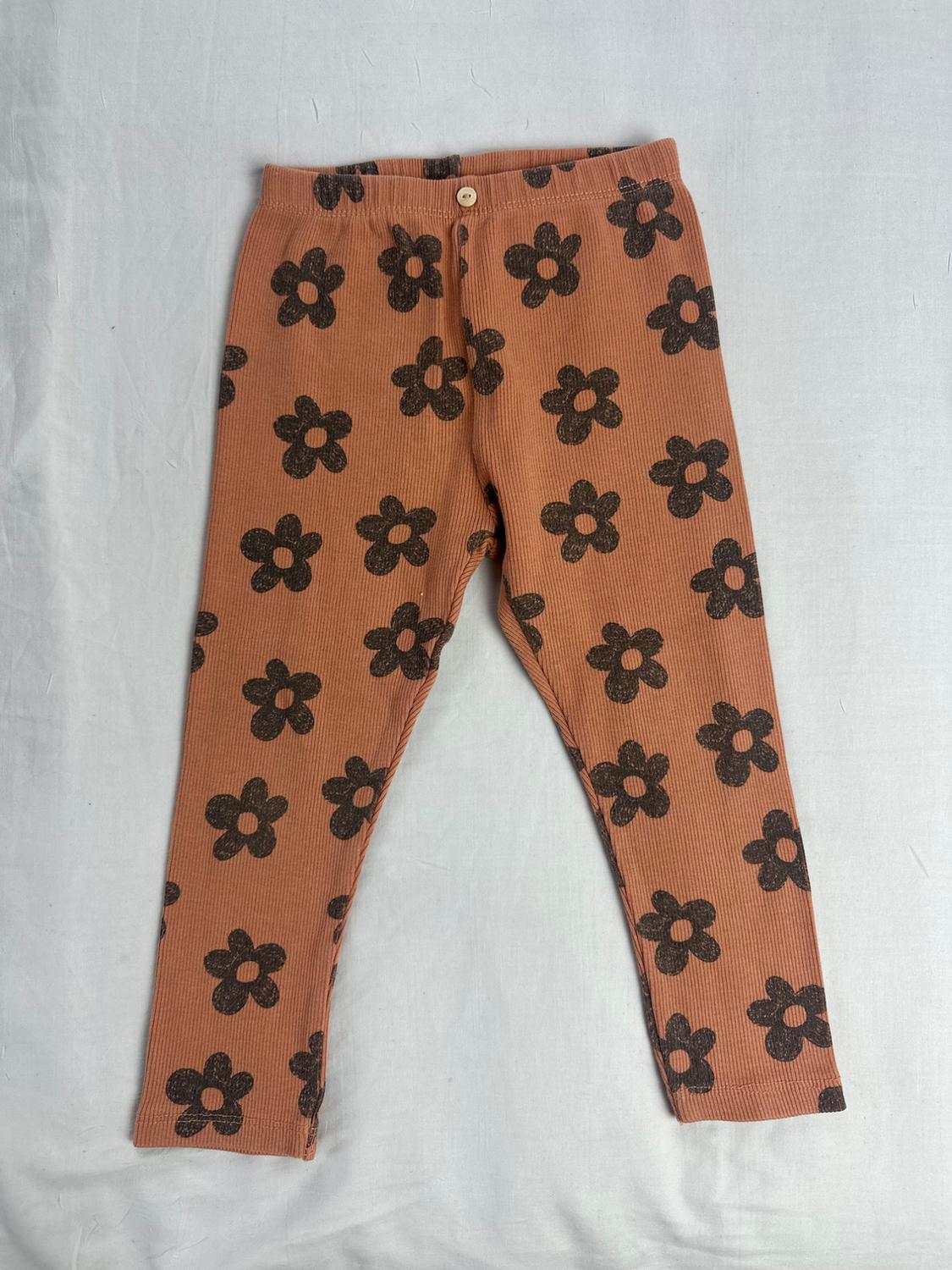 Ribbed knit leggings in terracotta with dark floral print and a small button at the waist.