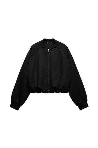 Front view of a black jacket with zipper, long sleeves, and elastic cuffs.