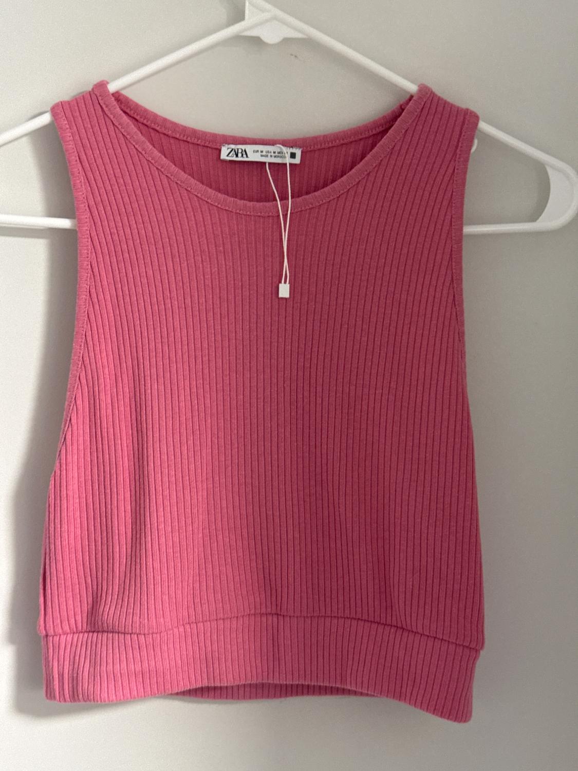 Front view of a pink sleeveless ribbed texture top.